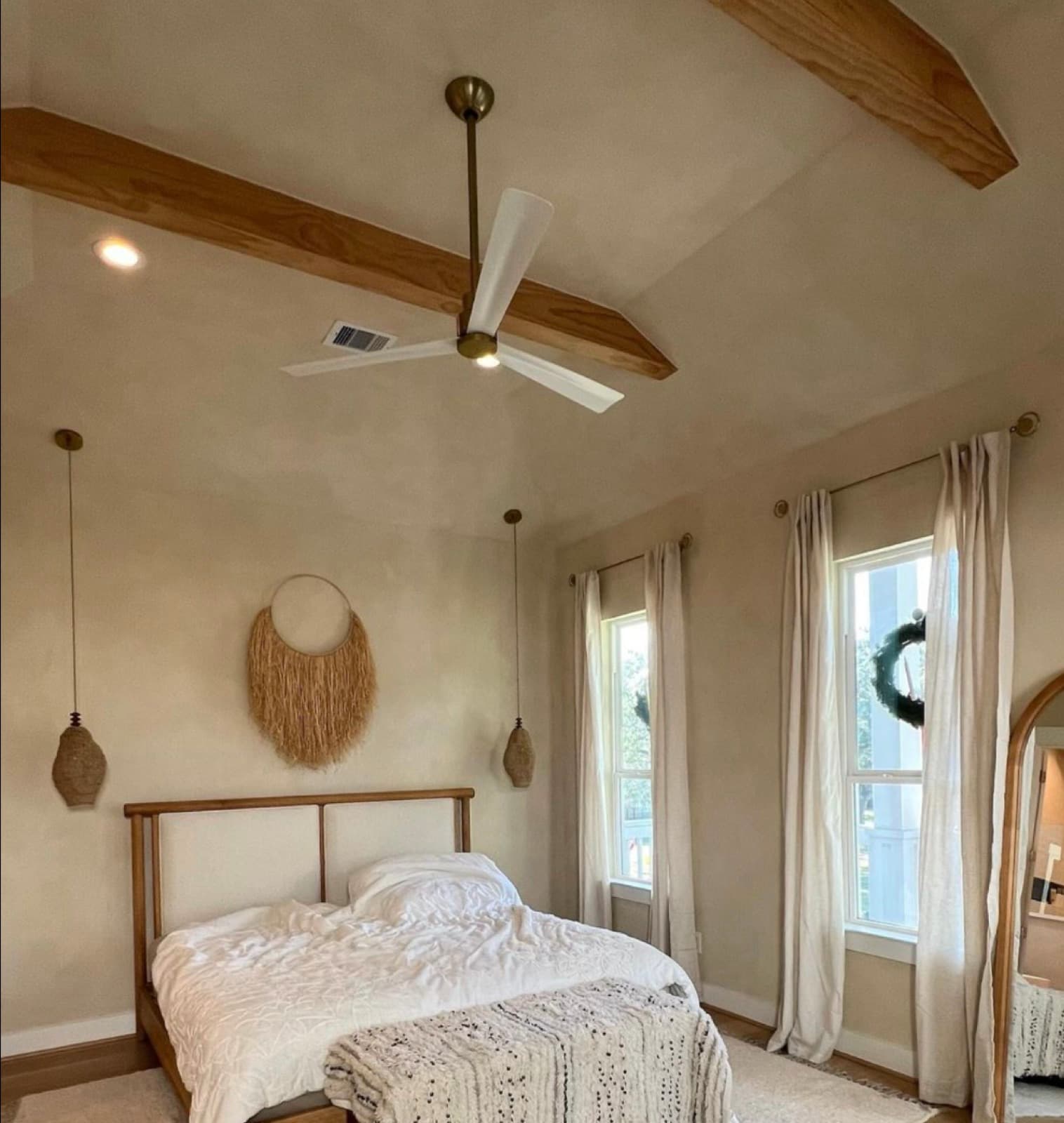 Warm plastered bedroom wall and vaulted ceiling with exposed wood beams